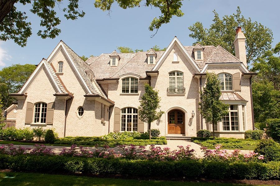 Light stone Fairfield Residence framed by lawn and mature trees.