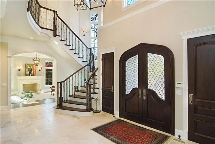 Formal foyer with curved stair and detailed millwork in the Blackthorn Residence.