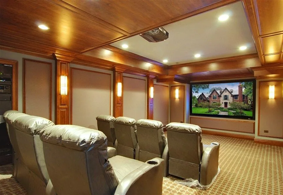 Wood-paneled home theater with tiered seating and recessed lighting.