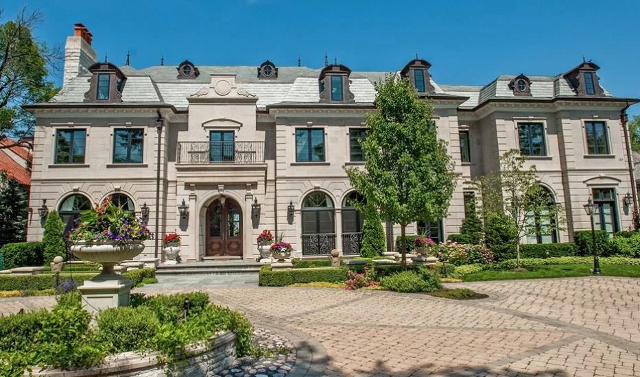 Large stone residence with a formal forecourt and symmetrical facade.
