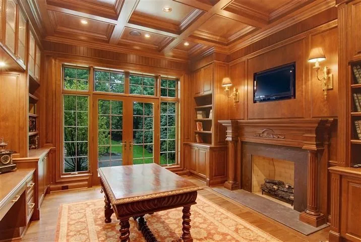 Paneled library with coffered ceiling and garden-facing windows in an SGE residence.