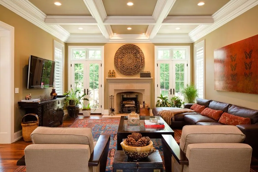 Family room with a coffered ceiling, central fireplace and tall windows.