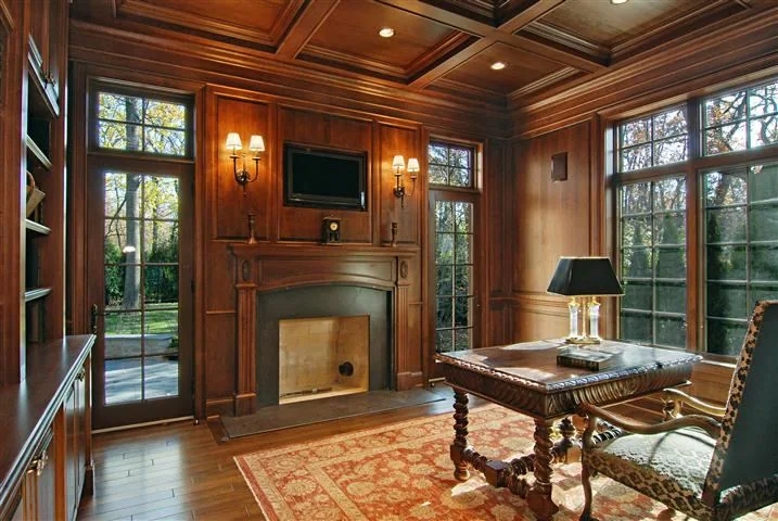 Paneled library with fireplace and tall windows in the Blackthorn Residence.