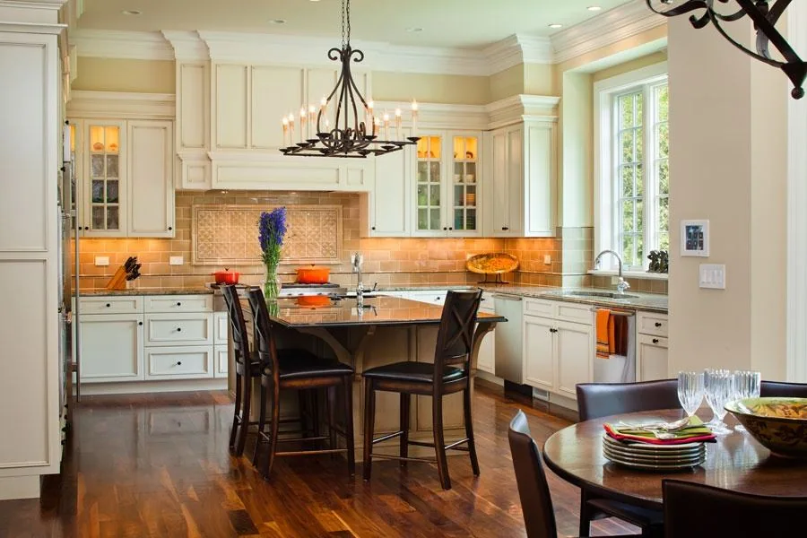 Kitchen with a central island, white cabinetry and timber flooring.